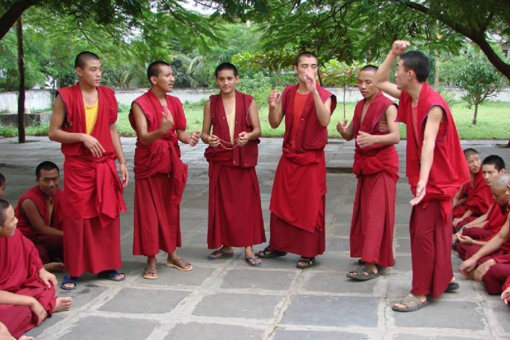 Monjes tibetanos debatiendo filosofía budista en Drepung Loseling
